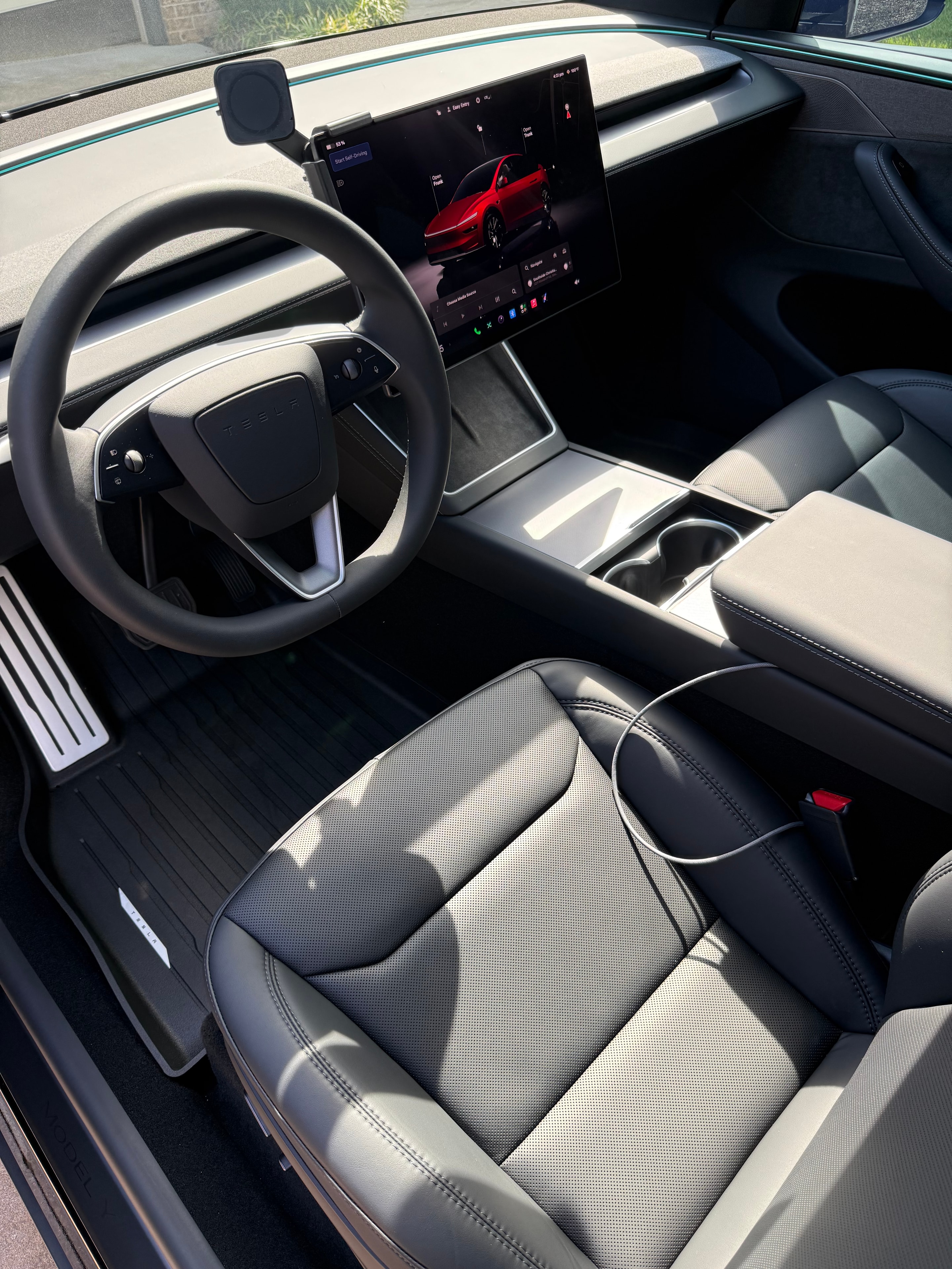 Tesla interior with clean steering wheel, seats, and center console after detailing